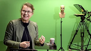 Marianne Gullberg i LARM-studion med en greenscreen bakom sig, som bland annat ger studenter möjlighet att öva på att göra en väderpresentation. Foto: Kennet Ruona