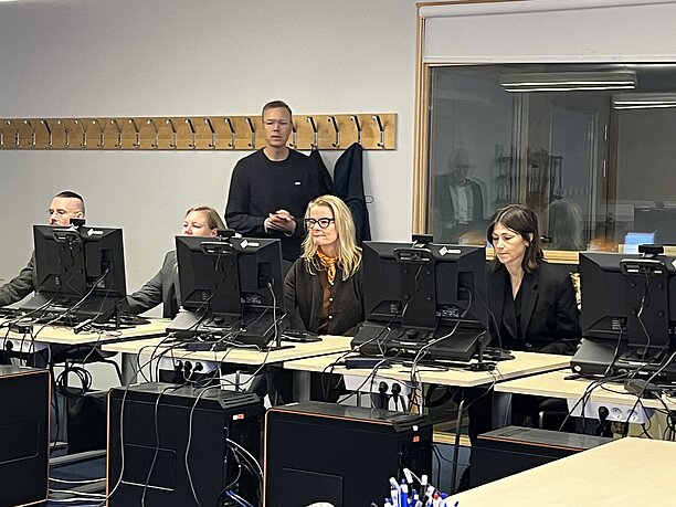 people sitting behind computers in a classroom